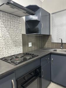 een keuken met een fornuis en een spoelbak bij Pendleberry Grove 33 in Bela-Bela