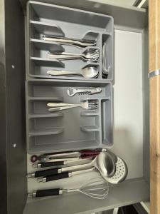 a drawer filled with silver utensils in a kitchen at Charmant Rez de Jardin 6 p 2 chambres et Parking in Savigny-sur-Orge