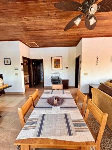 a dining room with a table and a ceiling fan at Sunset Views Apartment, West End in West End +24 photos