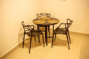 een tafel met vier stoelen en wijnglazen erop bij Apart Hotel Roda Viva in Abaeté +27 foto's