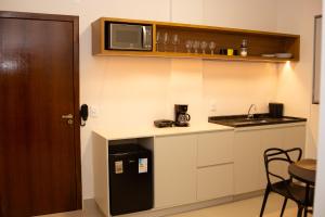 een kleine keuken met een spoelbak en een magnetron bij Apart Hotel Roda Viva in Abaeté