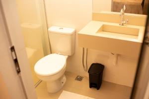 een kleine badkamer met toilet en wastafel bij Apart Hotel Roda Viva in Abaeté