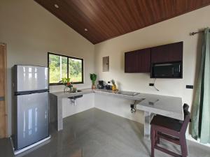 a large kitchen with a counter and a refrigerator at Casa Lapa in Aguas Zarcas