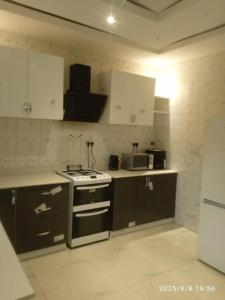 a kitchen with a stove and a microwave at Cutting Edge Guest House in Daranka