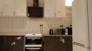 a kitchen with white cabinets and a stove and microwave at Cutting Edge Guest House in Daranka