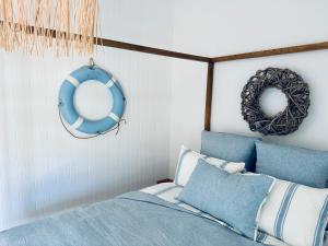 a bedroom with a bed with blue pillows and a mirror at Barbara's Beach House in Hallidays Point