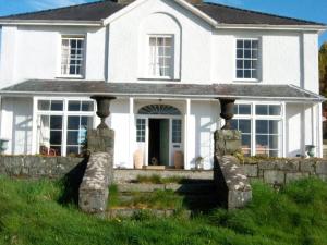 una casa bianca con una recinzione di pietra davanti di Castellmai a Caernarfon Altre 19 foto