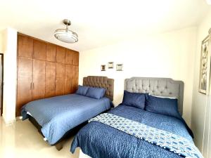 2 bedden in een slaapkamer met blauwe lakens bij Grand Retreat in La Paz +41 foto's