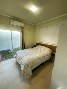 a bedroom with a bed and a large window at La Barra Apto 4 in Punta del Este