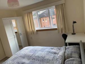 Raglan Glasgow Property في غلاسكو: غرفة نوم بها سرير ومكتب ونافذة