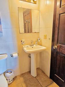 a bathroom with a sink and a mirror and a toilet at Sunset Views Apartment, West End in West End