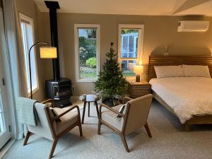 a bedroom with a bed and a christmas tree in it at Five Gables B&B in Qualicum Beach