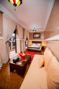 una sala de estar con un sofá y una cama en Riad Ta'achchaqa, en Marrakech 75 fotos más