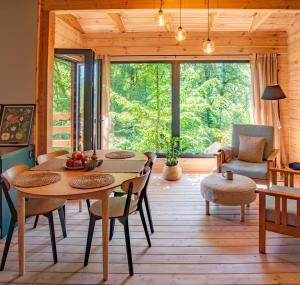 a living room with a table and chairs and a large window at Domek nad jeziorem w górach in Międzybrodzie Bialskie