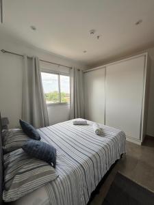 Un dormitorio con una cama con almohadas azules y una ventana. en TR Recoleta, en Asunción 24 fotos más