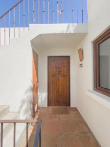 Casapueblo Rent Cachagua CP 27 في Cachagua: ممر مع باب وسلالم خشبية