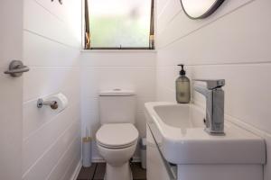 Blissful on Bay by Waiheke Pure في Waiheke Island: حمام صغير مع مرحاض ومغسلة