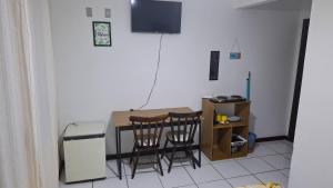 a small kitchen with a table and two chairs at Residencial DO MAR in Bombinhas