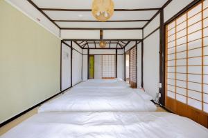 a row of beds in a room with windows at 温故知新 in Minamiboso