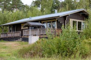 a log cabin with a porch and a deck at Brusta Stugor in Ödkarby
