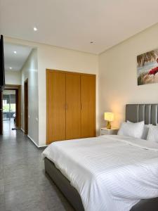 a bedroom with a large white bed and a television at Luxury and serenity HARHOURA in Temara