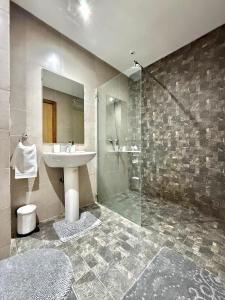 um banheiro com pia e chuveiro em La perle de HARHOURA- Piscine- CAN 2025 em Temara