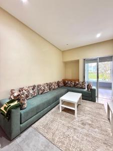 a living room with a green couch and a table at Luxury and serenity HARHOURA in Temara