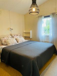 a bedroom with a large bed and a window at Brusta Stugor in Ödkarby