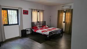 Villa Massai avec piscine au cœur de Saly في Sali Nianiaral: غرفة نوم بها سرير عليه زهور حمراء +87 صورة