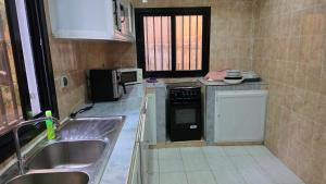 Villa Massai avec piscine au cœur de Saly في Sali Nianiaral: مطبخ صغير مع موقد ومغسلة