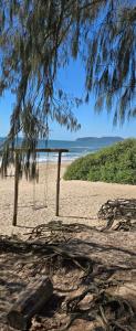 a swing on a beach with the ocean in the background at Recanto Dos Vargas - Seu refúgio em Floripa com atendimento dos anfitriões in Florianópolis