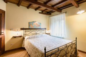 1 dormitorio con cama y ventana en Il Borgo Dei Corsi - Charming Holiday Apartments, en Ortignano Raggiolo