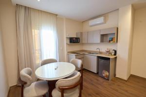 a kitchen with a table and chairs in a room at Settle Inn Rawda Apartments in Cairo