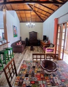 ein Wohnzimmer mit einem Tisch und einem Sofa in der Unterkunft Casa próxima ao Centro em Tiradentes - MG in Tiradentes