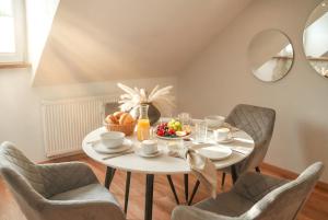 a dining room with a white table and chairs at MILPAU Bottrop1 - Zentrales, modernes Design-Apartment - Smart TV, Nespresso, für 4 Personen in Bottrop