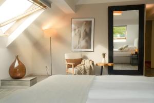 a bedroom with a bed and a mirror at MILPAU Bottrop1 - Zentrales, modernes Design-Apartment - Smart TV, Nespresso, für 4 Personen in Bottrop +12 photos