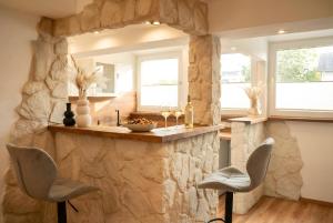 a kitchen with a stone counter and two chairs at MILPAU Bottrop1 - Zentrales, modernes Design-Apartment - Smart TV, Nespresso, für 4 Personen in Bottrop