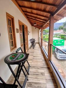 ein Balkon eines Hauses mit einem Tisch und Stühlen in der Unterkunft Casa próxima ao Centro em Tiradentes - MG in Tiradentes + 33 Fotos