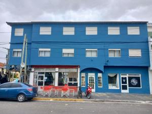 a blue building with tables and chairs in front of it at Rocio Club de Mar in Mar del Tuyú