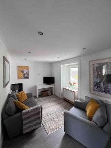 a living room with two couches and a television at Stylish One Bed Apartment in Edinburgh