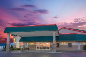 Super 8 by Wyndham Portage La Prairie MB في بورتاج لا بريري: محطة وقود مع غروب الشمس في الخلفية