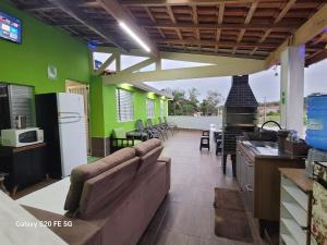 a kitchen with green walls and a couch in a room at Pousada do Sossego Mar e verde 3 in Itanhaém