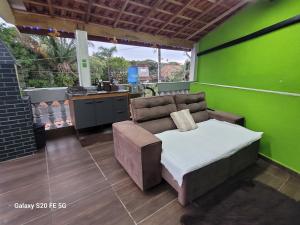 a living room with a couch and a green wall at Pousada do Sossego Mar e verde 3 in Itanhaém