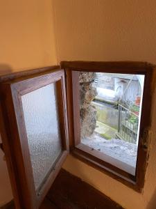 two windows in a room with a view of a staircase at La Casetta in Bannio