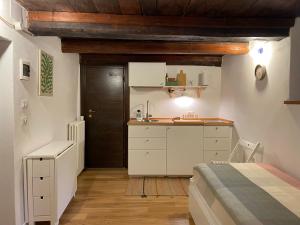 a bedroom with a bed and a kitchen with a sink at La Casetta in Bannio