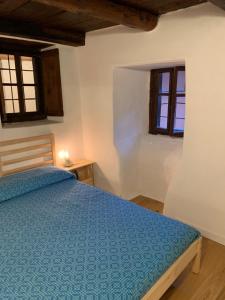 a bedroom with a bed and two windows at La Casetta in Bannio