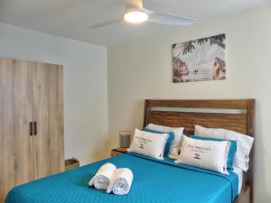 a bedroom with a blue bed with two towels on it at Amazing 2BR with private pool in Oyster Pond in Oyster Pond