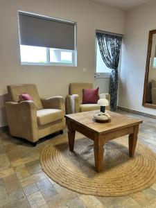 Luxe studio voor 2 personen en groot zwembad في Sint Jozefsdal: غرفة معيشة مع كرسيين وطاولة قهوة