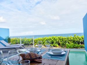 a table with wine glasses and a view of the ocean at Amazing 2BR with private pool in Oyster Pond in Oyster Pond