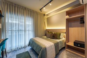 una camera da letto con un letto e una grande finestra di Edificio Hauz Mitre Vila Clementino a San Paolo Altre 45 foto